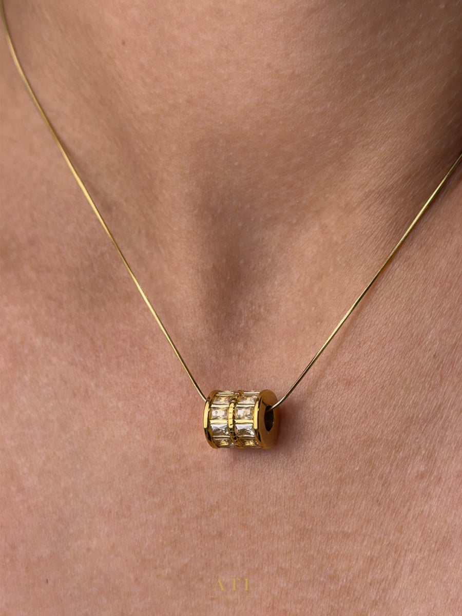 Close-up of the crystal-set barrel pendant and delicate snake chain