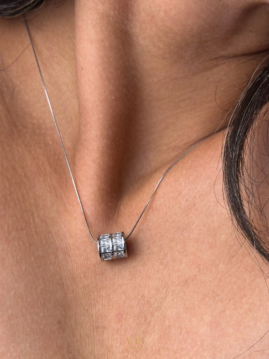 Close-up of the crystal-set barrel pendant and delicate snake chain