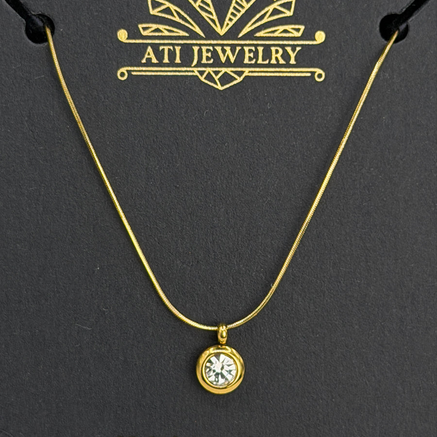 The Elara Necklace in 18K gold finish with clear crystal charm on ATI Jewelry card