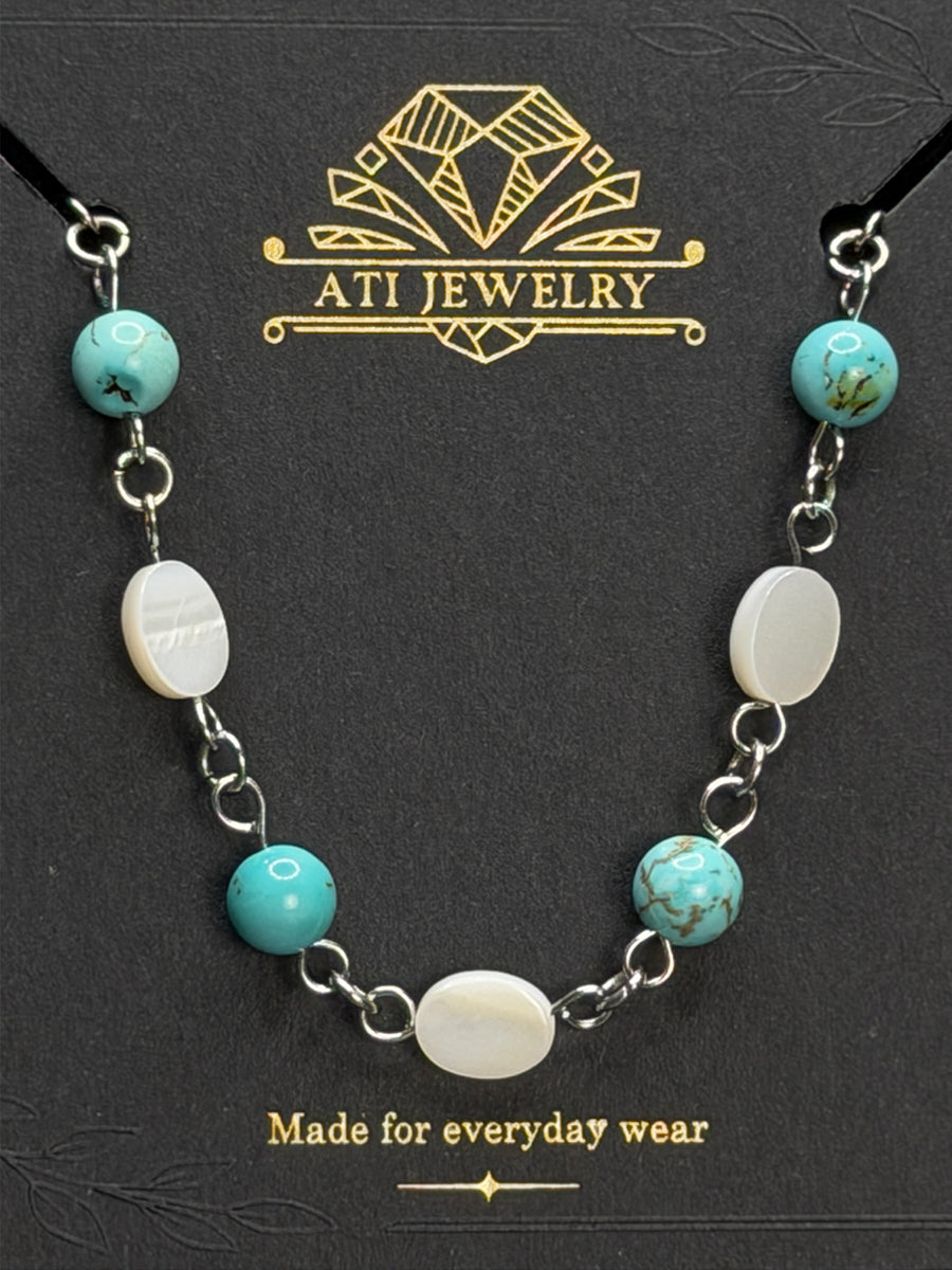 The Shoreline Necklace in Polished Stainless Steel with shell and turquoise beads