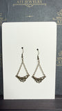 Antique brass-tone chain drop earrings with open floral and textured leaf details, displayed on an ATI JEWELRY Vintage Collection card.